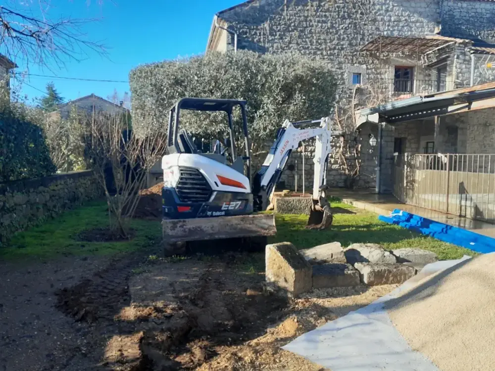 Travaux de terrassement de jardin avec mini-pelle pour pose de réseaux enterrés